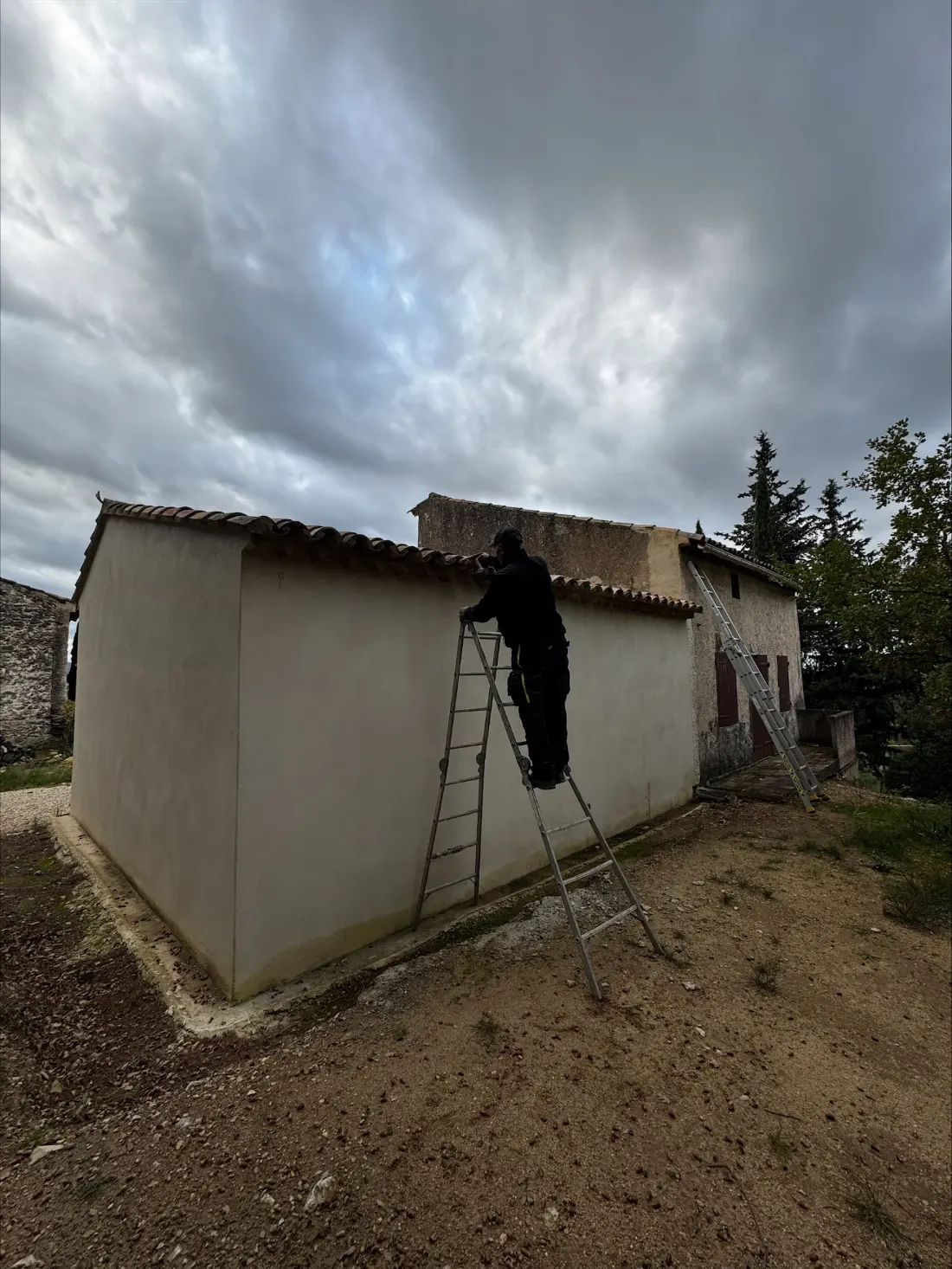 Mohamed Moussaoui, maçon à Cavaillon, enduisant la façade d'une maison