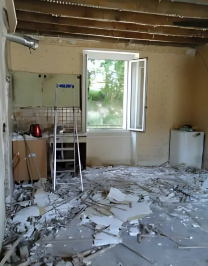 Cuisine avant rénovation : plafond ouvert et gravats au sol