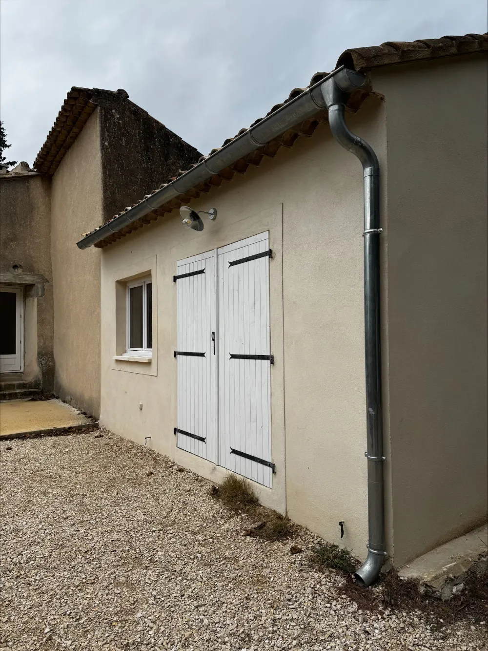 Façade de maison enduite avec portes en bois